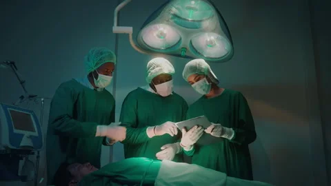 Group of mixed-races professional surgeons operating in hospital operating ro Vídeos de archivo 195208409