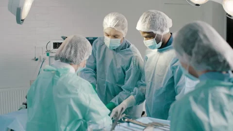 Group of mixed-races surgeons in uniform performing heart transplant surgery Stock Footage 272812568