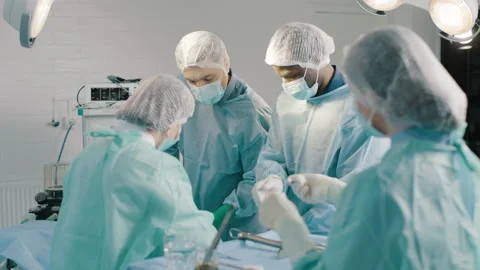 Group of mixed-races surgeons in uniform performing heart transplant surgery Video stock 272817497
