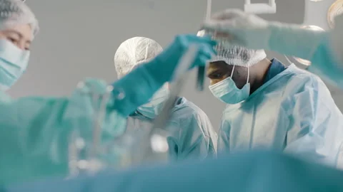 Group of mixed-races surgeons in uniform performing heart transplant surgery Stock Footage 272819901