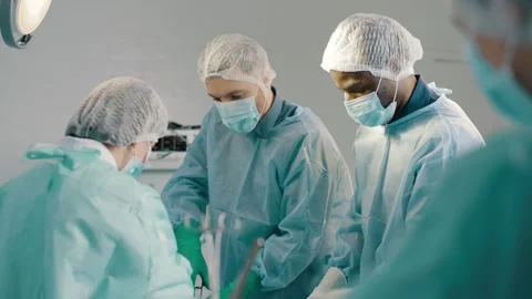 Group of mixed-races surgeons in uniform performing heart transplant surgery Stock Footage 272827054