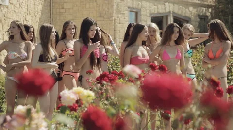 Group of models in bikinis in a park with roses Stock Footage 54789060