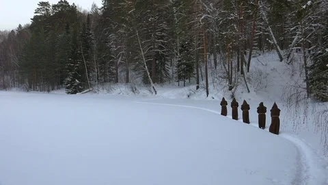 Group of monks in hood robe walking along winter snow trail in forest Stock Footage