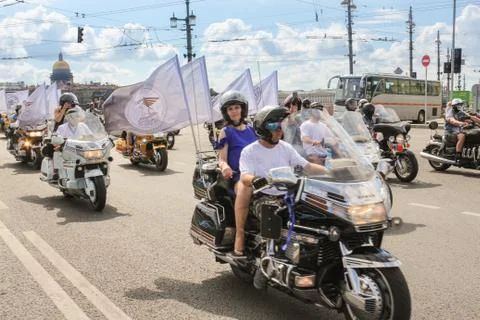 A group of motorcyclists with white flags. 库存照片