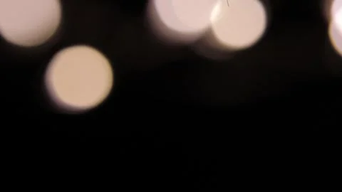 A group of moving lights in the dark, pointing upwards and out of frame. Видео 317487007
