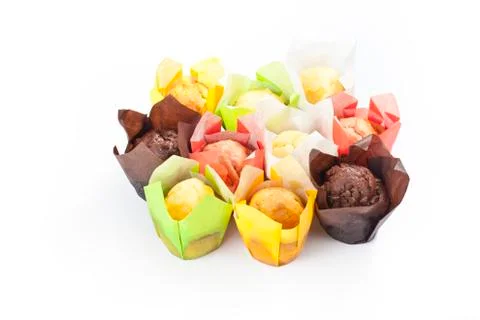 Group muffins in colored paper on a white background Stock Photos