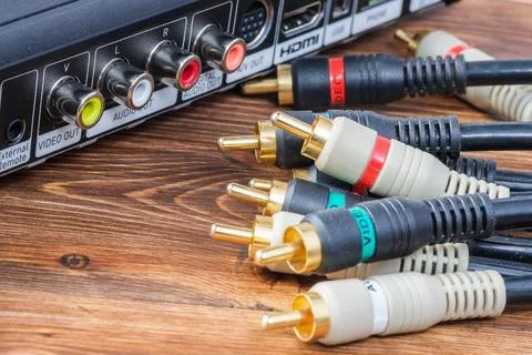 Group of multi colored analog RCA audio and video cable connectors near a mul Stock Photos