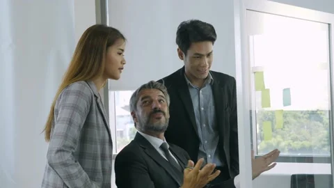 Group of multi ethinic in formal suit, discussing business plan on glass board Stock Footage 136467627