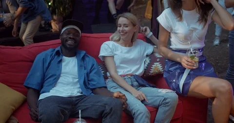 Group of multi-ethnic young friends chatting drink cocktails sitting on sofa Stock-Footage 115389908