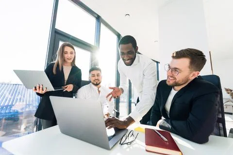 Group of multi-ethnic young software developers working at the computer Stock Photos