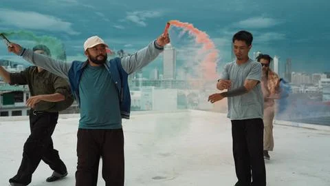 Group of multicultural hipster playing color flare at rooftop. Endeavor. Stock Photos