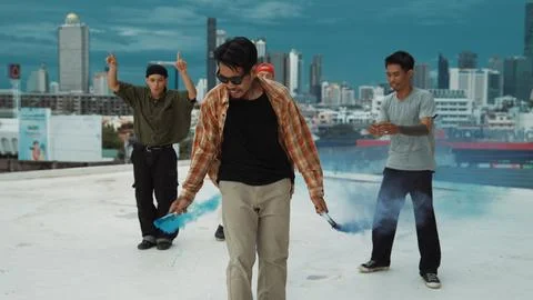 Group of multicultural hipster playing color flare at rooftop. Endeavor. Stock Photos