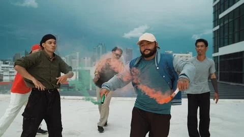 Group of multicultural hipster playing color flare at rooftop. Endeavor. Stock Photos