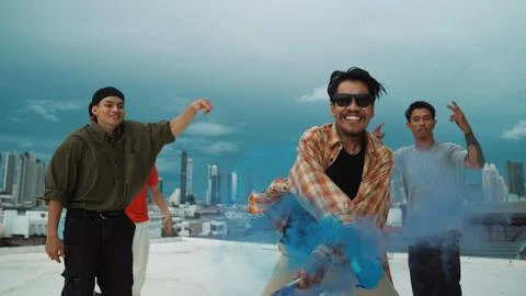 Group of multicultural hipster playing color flare at rooftop. Endeavor. Stock Photos