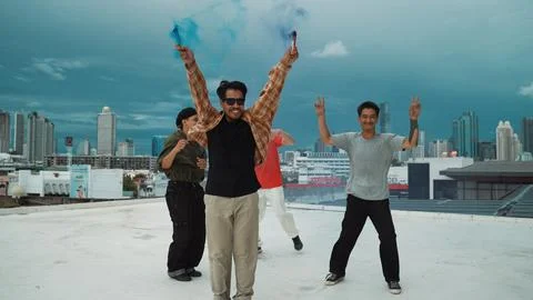 Group of multicultural hipster playing color flare at rooftop. Hiphop. Stock Photos
