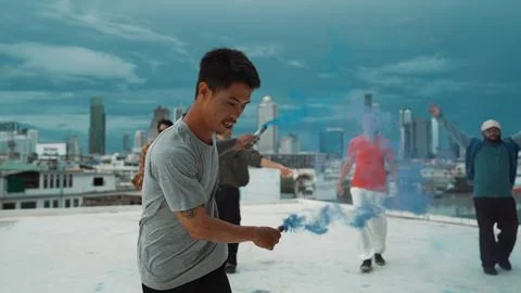 Group of multicultural hipster playing color flare at rooftop. Hiphop. 写真素材