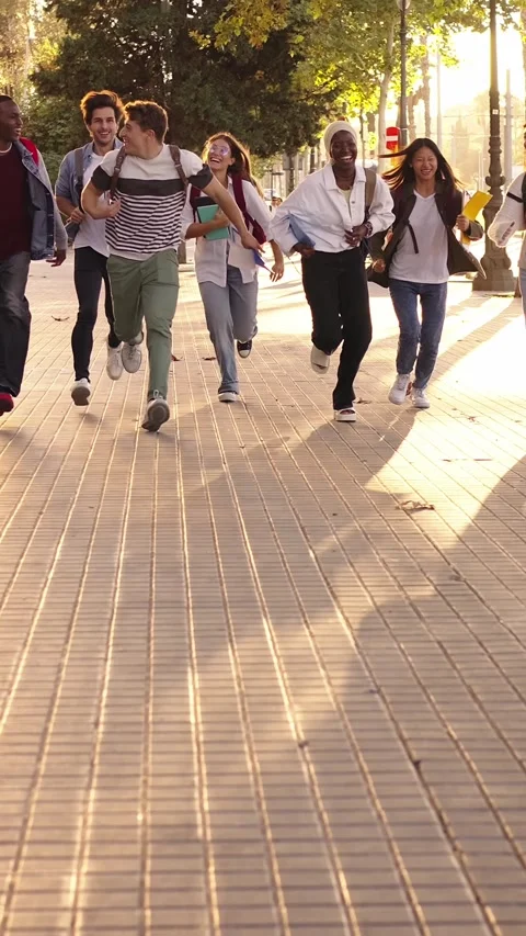Group of multicultural students running leaving the university, cheerful and Stock Footage 269242924