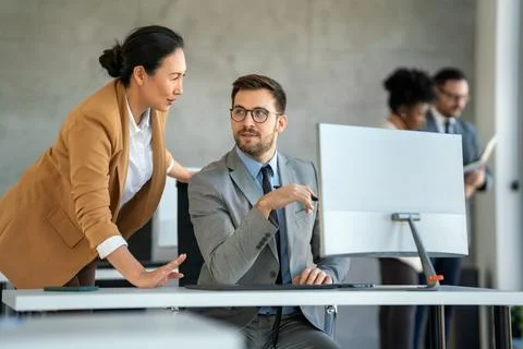 Group of multiethnic business people analyzing data using computer while working Stock Photos