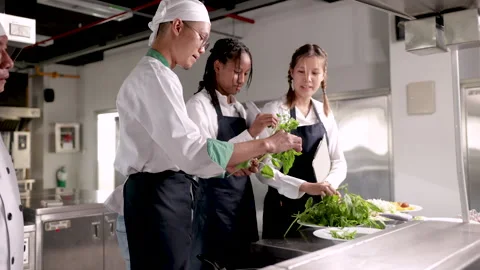 Group of multiethnic chef's trainees practicing in cooking school, cheerful.. Stock Footage 246720896