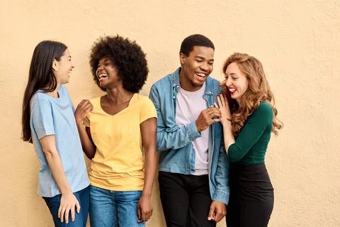 Group of multiethnic friends laughing while standing Stock Photos