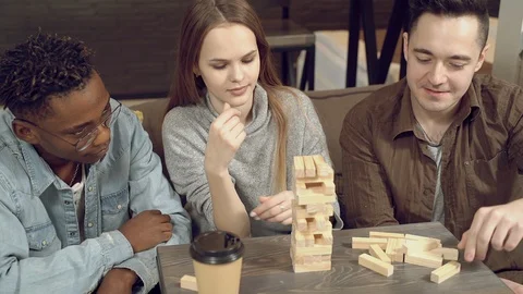 Group of multiethnic happy friends playing block removal game at home. Stock Footage 129759752