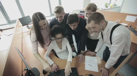 Group of multiethnic office workers around colleague using computer. Slow motion Stock Footage 57244674