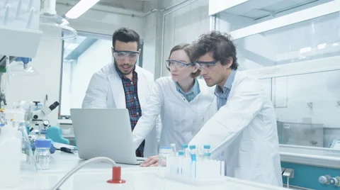 Group of Multiethnic Students in Coats using Laptop in Laboratory Stock Footage