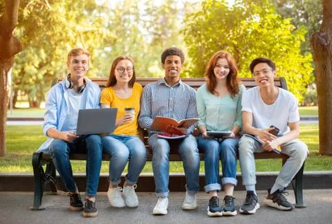 Group Of Multiethnic Students Posing Sitting On Bench Learning Outside Stock-Fotos