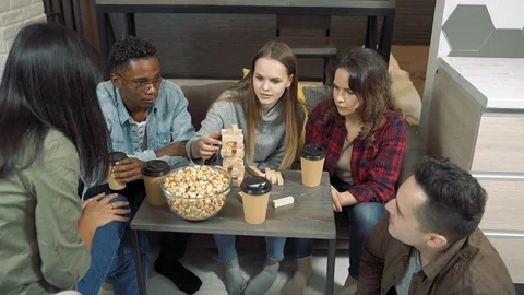 Group of multinational friends playing block removal game in the living room Stock Footage 122688635