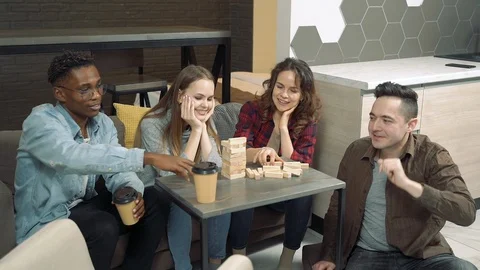 Group of multinational friends playing block removal game in the living room Stock Footage 123150080