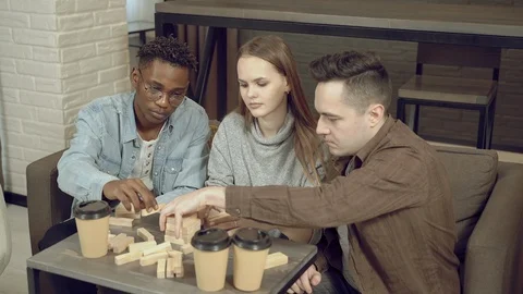 Group of multinational friends playing block removal game at home Stock Footage 129495676