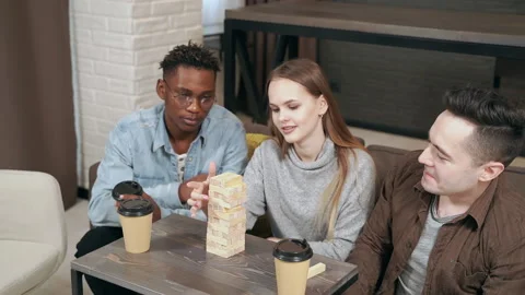 Group of multinational friends playing block removal game at home Stock Footage 148098415