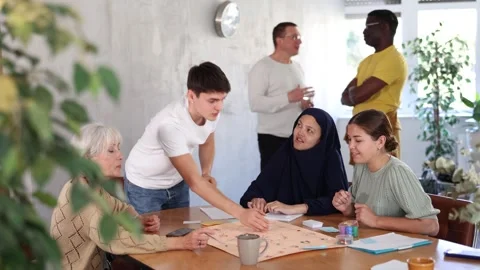 Group of multinational students of different years play a board game with Stock Footage 341379622