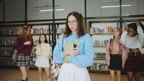 A group of multiracial students bully a loser classmate in a modern library Stock Footage 300737140