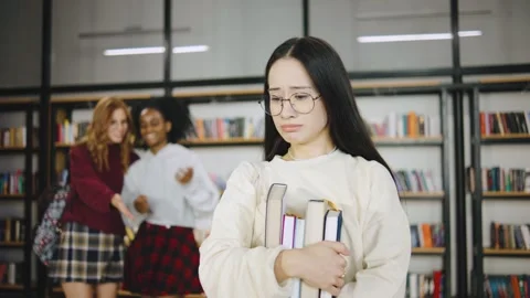 A group of multiracial students bully a loser classmate in a modern library Stock Footage 300737765