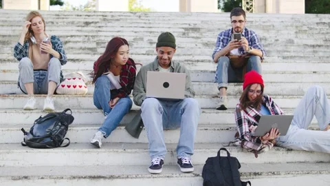 Group of multiracial students engaged in various activities on outdoor stairs Stock Footage 303250305