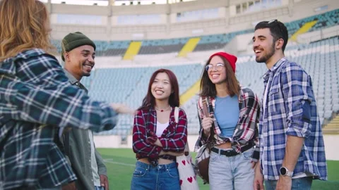 A group of multiracial students say hello and have fun at the stadium during the Stock Footage 303247556