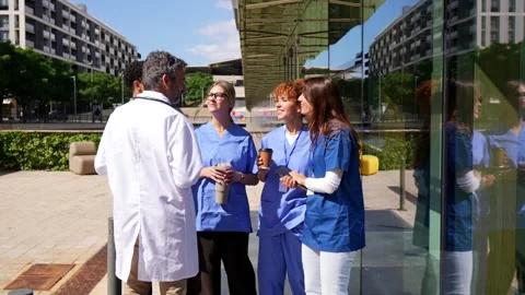 Group of nurses and doctors having a coffee break outside a modern hospital Stock Footage 338250515