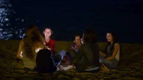 Group o young people spending the night on beach in the moonlight Stock Footage 64124407