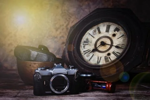 Group of objects on wood table. antique wooden clock, hourglass, old camera , 写真素材