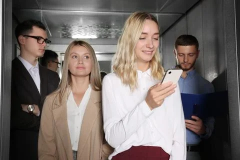 Group of office workers in modern elevator Stock Photos