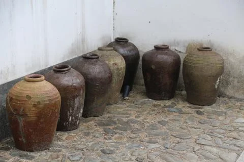 A group of old wine jars, standing on the ground in an ancient chinese cour.. Stock Photos