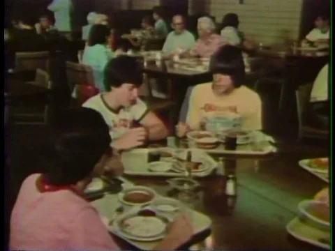 A group of older students mingle in a cafeteria and relax in a dorm during the Stock Footage 75008832
