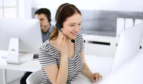 Group of operators at work. Call center. Focus on beautiful woman receptionist Stock Photos