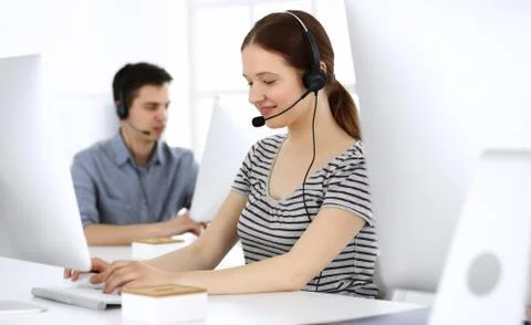 Group of operators at work. Call center. Focus on beautiful woman receptionist Foto stock