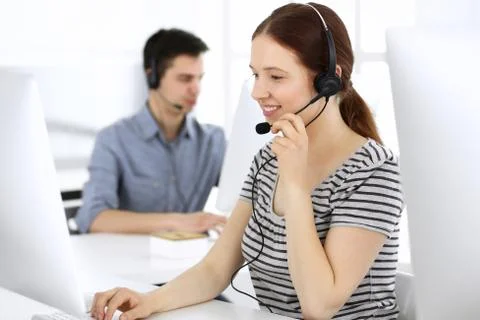 Group of operators at work. Call center. Focus on beautiful woman receptionist Stock Photos