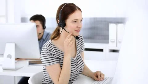 Group of operators at work. Call center. Focus on beautiful woman receptionist Stock Photos
