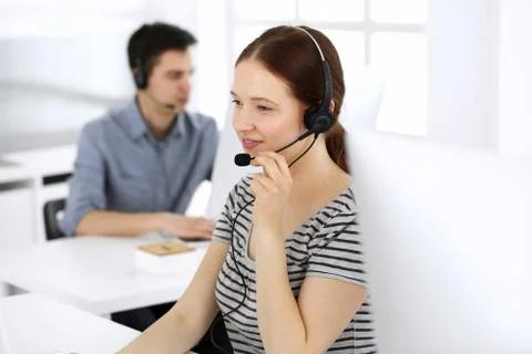 Group of operators at work. Call center. Focus on beautiful woman receptionist Stock Photos