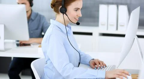 Group of operators at work. Call center. Focus on beautiful woman receptionist Stock Photos