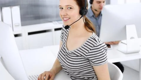 Group of operators at work. Call center. Focus on beautiful woman receptionist Stock Photos